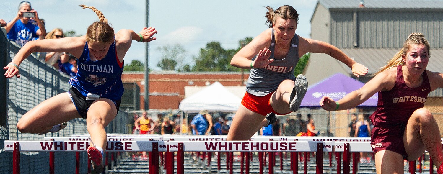 Savana Smith of Quitman and Allie Hooton of Mineola compete in the 100m hurdle prelims Friday in Whitehouse. [more prelims and finals photos]